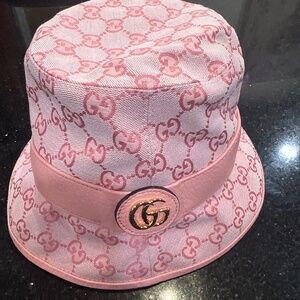 Gucci GG Supreme bucket hat in pink canvas with a leather band and gold GG logo.